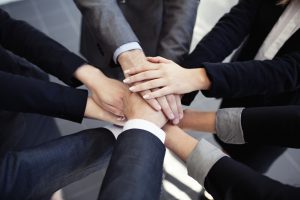How Training Can Help Build a Reputation of Trust Group of business people joining hands.